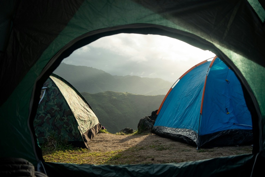 Tents on a green mountain ridge at dawn